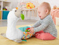 Ein Baby spielt mit einem Fisher-Price Lama-Spielzeug.