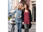 Zwei Frauen in einem Jeanshemd und einem langen roten Oberteil mit einem schwarzen Cardigan gehen mit einem Fahrrad.
