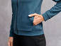 Eine Frau trägt eine dunkelblaue Trainingsjacke mit Reißverschluss.