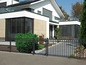 Ein modernes Haus mit einem schwarzen Metallzaun mit runden Spitzen.