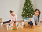 Zwei Mädchen spielen mit einem Bauernhof-Set und Tierfiguren zu Weihnachten.