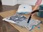 Eine Person verwendet einen Staubsauger, um Kleidung in Vakuumverpackungen zu versiegeln.