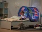 Ein Kind sitzt in einem PJ Masks Zelt auf einem Bett.