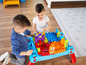 Zwei Jungen spielen mit einem Mega Bloks Bautisch.