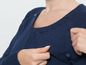 Ein dunkelblauer Strickpullover mit verdeckten Knöpfen zum Stillen.