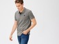 Mann trägt ein graues Poloshirt mit einem Bootslogo und blaue Jeans.