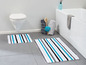 Zwei Badezimmerteppiche mit blauen Streifen in einem Badezimmer.