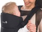 Ein Baby wird in einem schwarzen Safety 1st Tragetuch getragen.