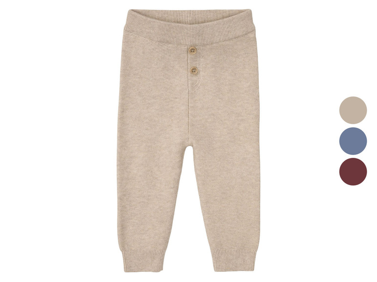 Beige gestrickte Babyhose mit Knöpfen.