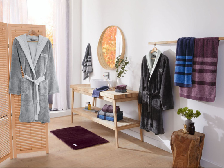 Zwei Bademäntel und Handtücher im Badezimmer.