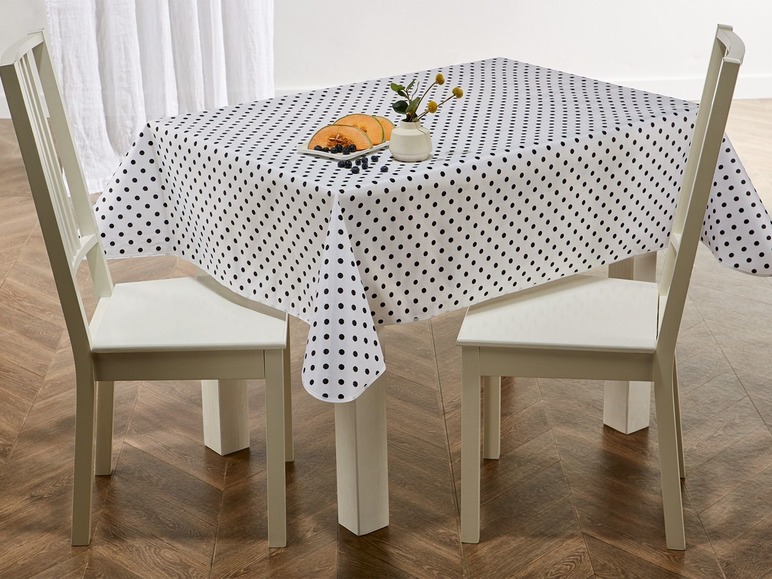 Weißer Tisch mit schwarzem Tupfen-Tischdecke.