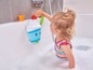 Ein Mädchen spielt mit Badezeug in der Badewanne.