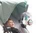 Ein Baby in einem Kinderwagen mit einem Tiny Love Mobile