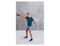 Mann in Sportkleidung mit einer roten Kettlebell beim Training.