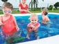 Kinder spielen in einem aufblasbaren Pool mit bunten Schwimmringen.