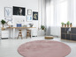 Ein runder rosa Teppich in einem modern eingerichteten Raum mit einem Schreibtisch und einem Bücherregal.