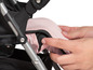 Ein rosafarbener Kinderwagen mit einer Hand, die das Verdeck verstellt.