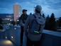 Mann mit einem grauen Rucksack mit einem grünen Licht auf dem Rücken