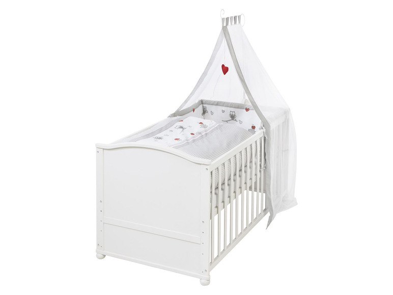 Weißes Babybett mit grau-weißem Bettzeug und Moskitonetz.