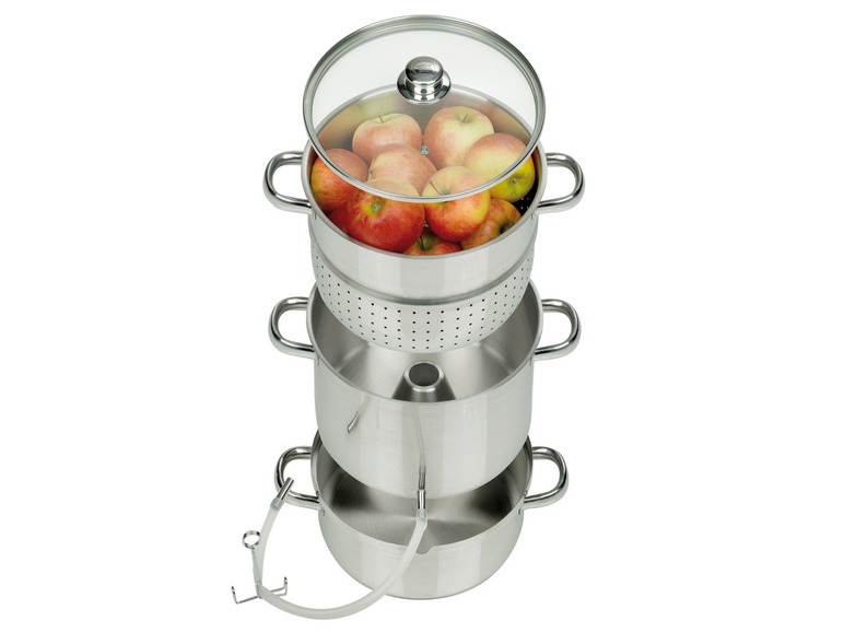 Ein Edelstahl-Saftpresser mit Äpfeln zur Herstellung von Apfelsaft.