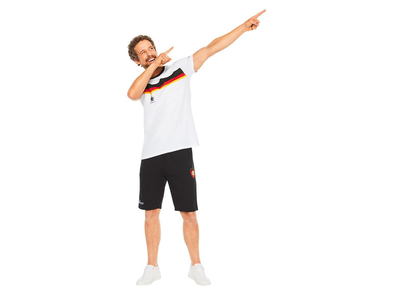 Mann trägt ein weißes T-Shirt mit deutscher Flagge und schwarze Shorts.