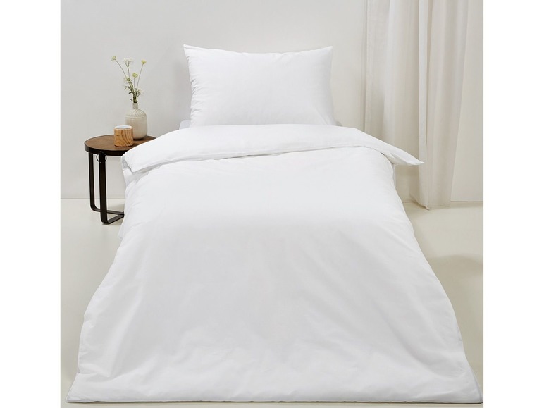 Weiße Bettwäsche mit einem Kissenbezug.