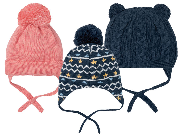 Drei Strickmützen mit Bommel, zwei blaue mit Sternen und eine rosa.