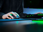 Eine Hand, die eine Razer-Maus auf einem Mauspad benutzt, mit einer Tastatur im Hintergrund.