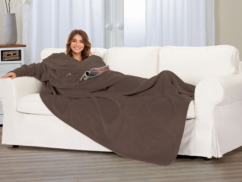 Frau auf einer Couch mit einer braunen Fleece-Decke.