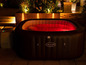 Ein aufblasbares Lay-Z-Spa Whirlpool mit rot beleuchtetem Wasser.