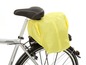 Ein silbernes Fahrrad mit einer gelben Regenhülle am Gepäckträger.