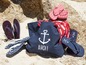 Strandtasche, Flip-Flops und Handtuch mit maritimem Muster.
