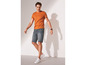 Mann in einem orangefarbenen T-Shirt und blauen Jeans-Shorts.