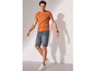 Mann in einem orangefarbenen T-Shirt und blauen Jeans-Shorts.
