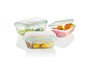 Drei transparente Aufbewahrungsbehälter mit grünen Rändern, gefüllt mit Obst und Keksen.