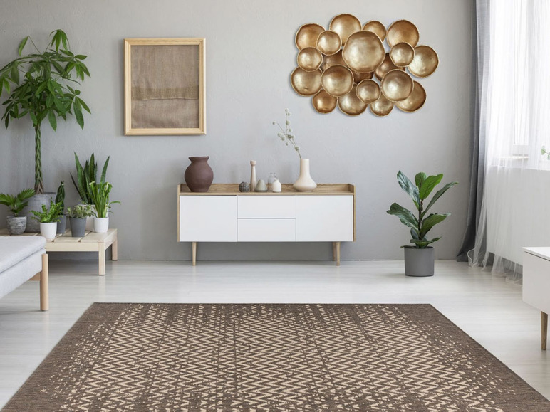 Ein Chevron-Teppich in einem modernen Interieur mit goldener Wanddekoration.