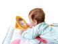 Ein Baby schaut sich in einem Spiegel auf einer Spielmatte an.