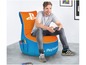 Ein Mann sitzt in einem orange-blauen PlayStation Beanbag-Sessel.