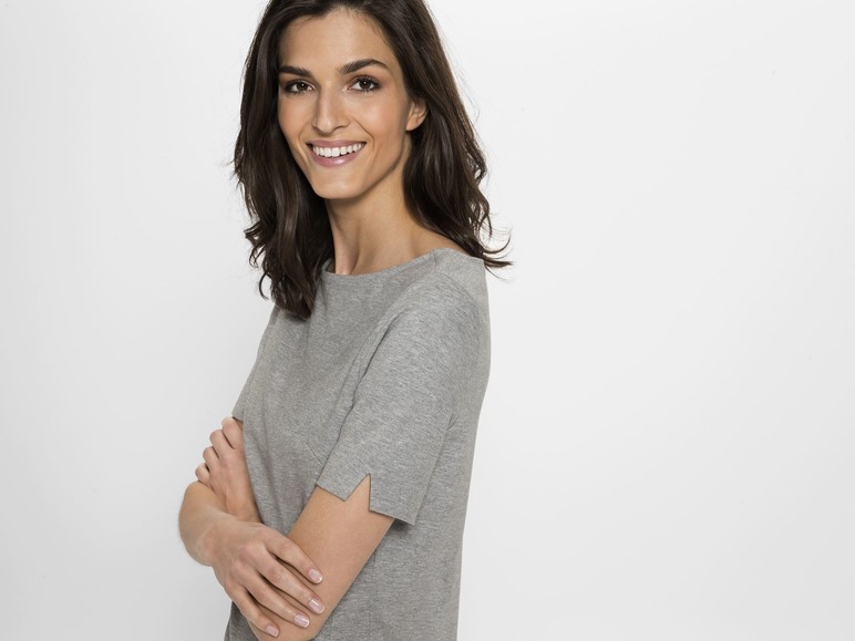 Frau in einem grauen T-Shirt mit kurzen Ärmeln.