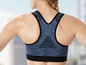 Eine Frau trägt einen blauen Sport-BH mit Mesh-Einsätzen.
