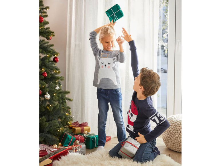Zwei Kinder spielen mit Geschenken zu Weihnachten.