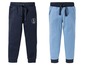 Zwei Jungen-Jogginghosen, eine dunkelblau mit Anker und eine hellblau.