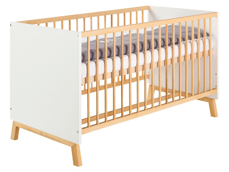 Ein weißes Babybett mit Holzlatten