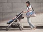 Eine Frau schiebt einen Kinderwagen mit einem Baby und einer Oh My Baby! Tasche.