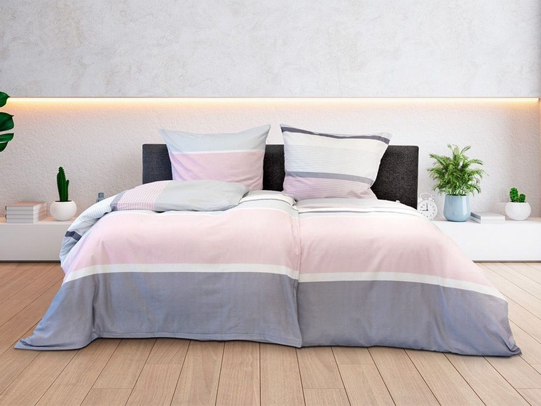 Eine rosa-graue Bettwäsche mit Streifen.