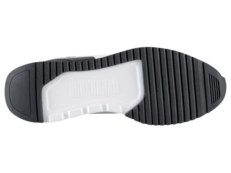 Schwarze Gummisohle eines weißen Puma-Sneakers.