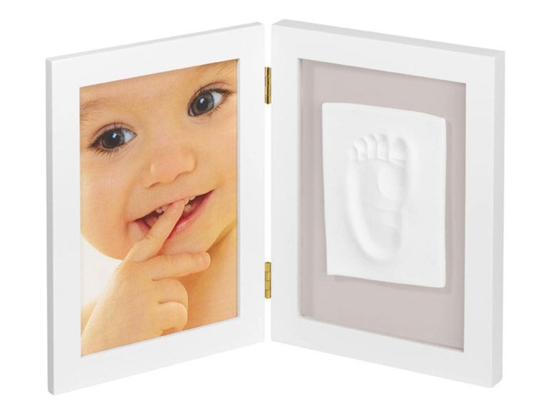 Ein weißer Bilderrahmen mit einem Babyfoto und einem Abdruck eines Babyfusses.