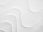 Nahaufnahme eines weißen Matratzenbezugs mit Wellendesign.