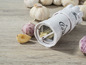 Knoblauchpresse von Genius mit gepresstem Knoblauch und frischem Knoblauch.