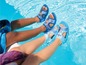 Zwei Kinder tragen wasserdichte Sandalen mit Frozen- und Paw Patrol-Designs in einem Schwimmbad.